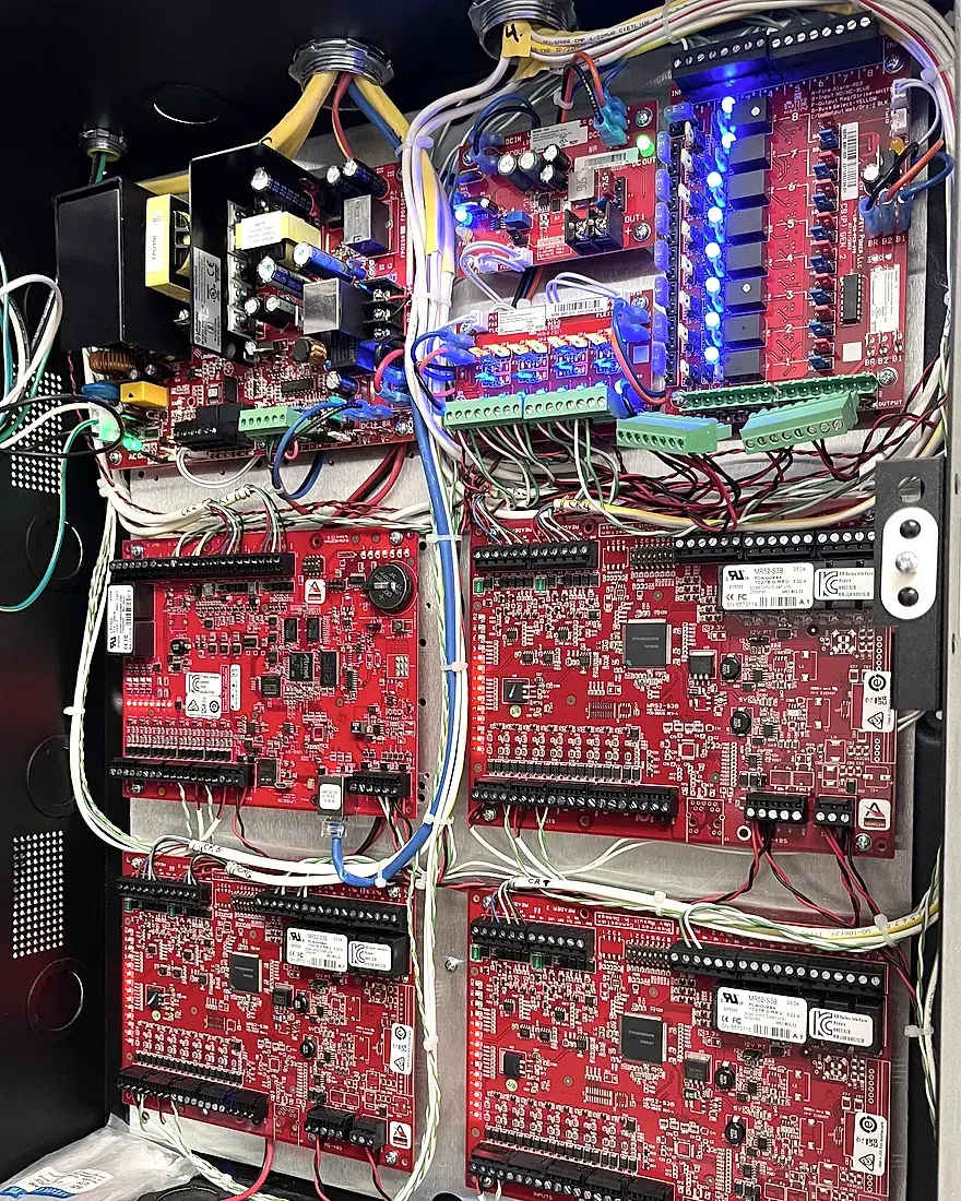 An access control panel with its boards and door wiring landed and labelled