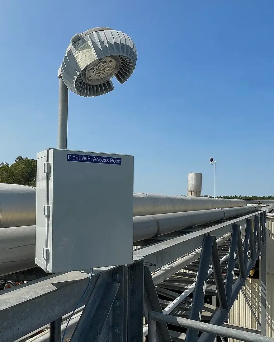A weatherproof enclosure holding a plant Wi-Fi access point on a pipe rack